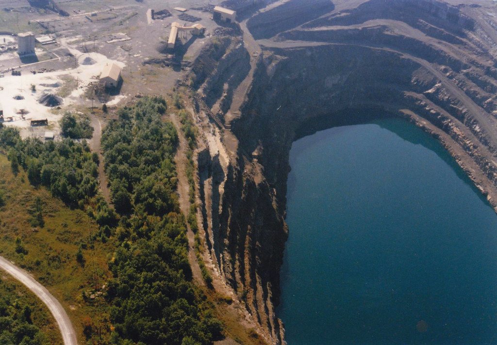 An open-pit mine with a flooded pit floor, seen from the air