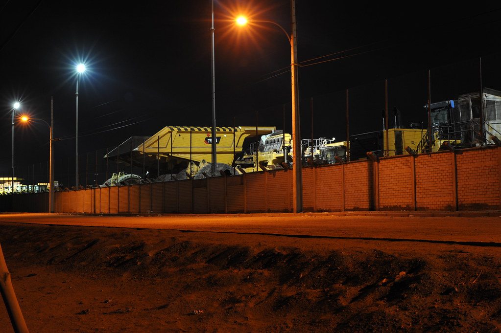 Heavy plant and haul equipment at a site yard at night